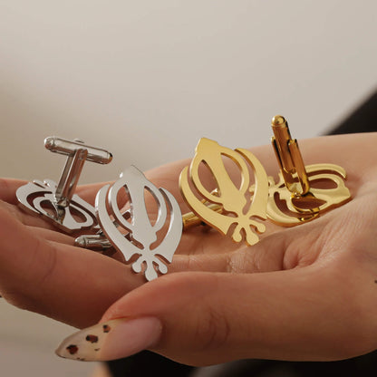 Hand holding both gold and silver Punjabi Sikh cufflinks with Khanda design, highlighting color options in stainless steel.