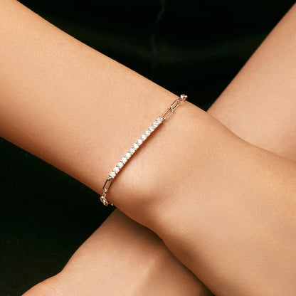 Silver bracelet on a person's wrist against a black background